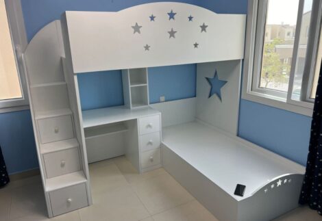Two beds, a desk and a side stair with drawers
