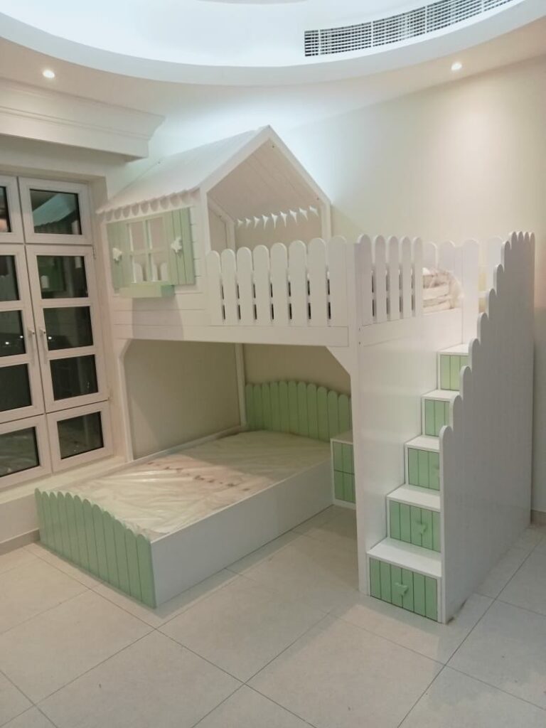 A bunk bed with a hut at the top and a fence that resembles a garden fence