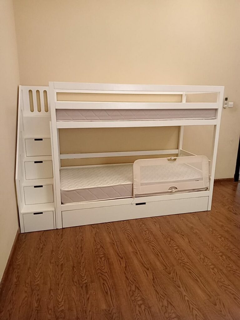 Bunk bed with storage drawers under the stairs and a lower drawer under the bed