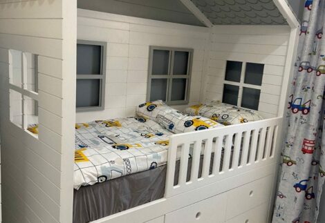 A high bed with six windows and a covered hut frame.